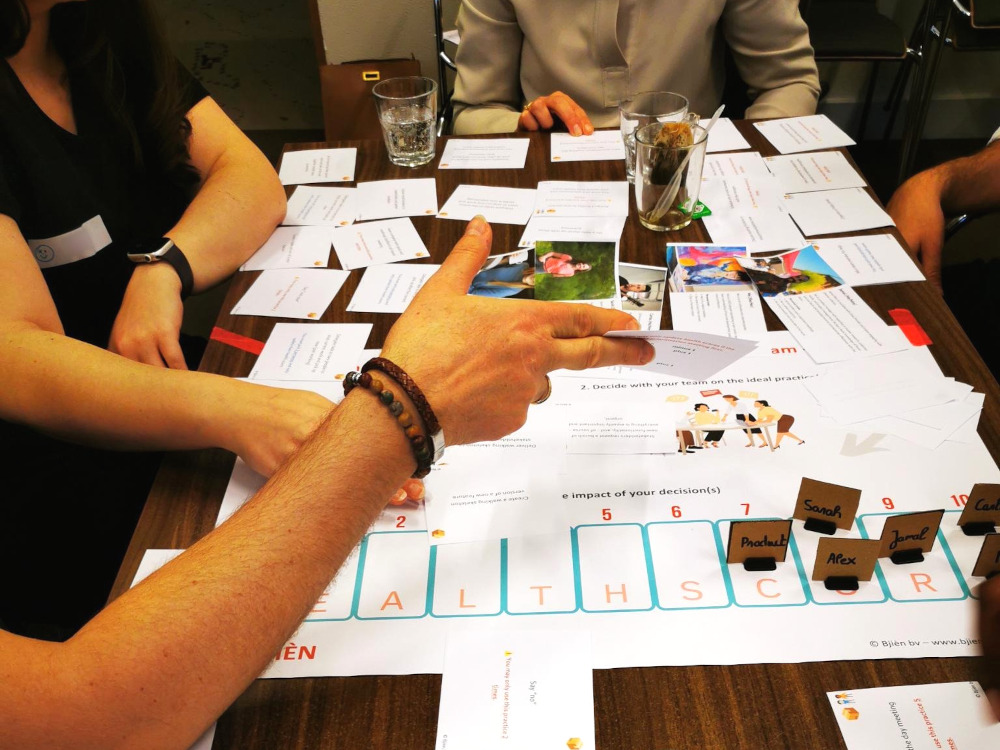 People playing the board game, with a playing board, pawns and cards.