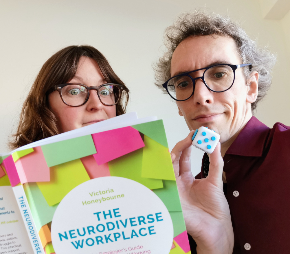 Daphné en Dietrich met een boek over neurodiversiteit op het werk en een fidget cube.